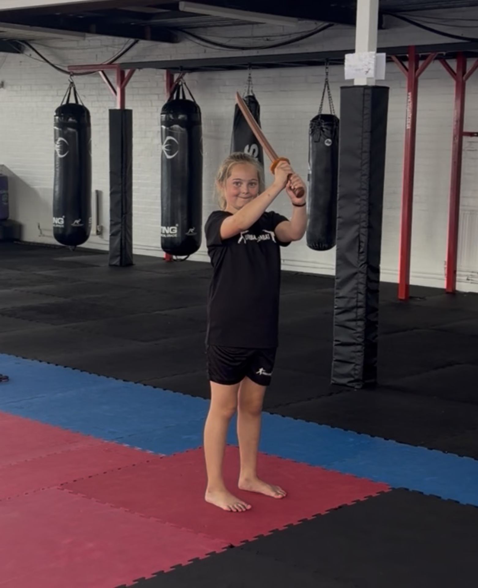 Student raising a wooden sword at Urban Combat Ipswich