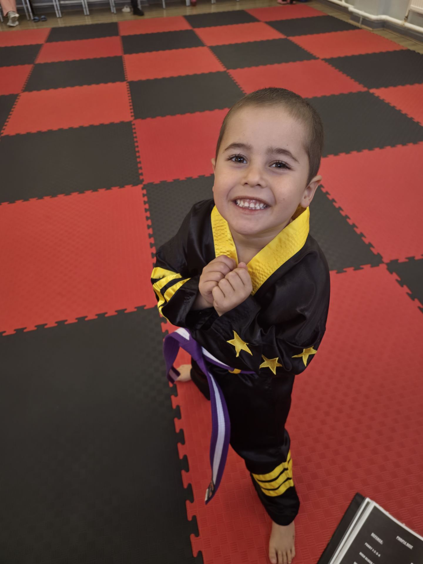 Young Mini Cobras student smiling with his new purple belt