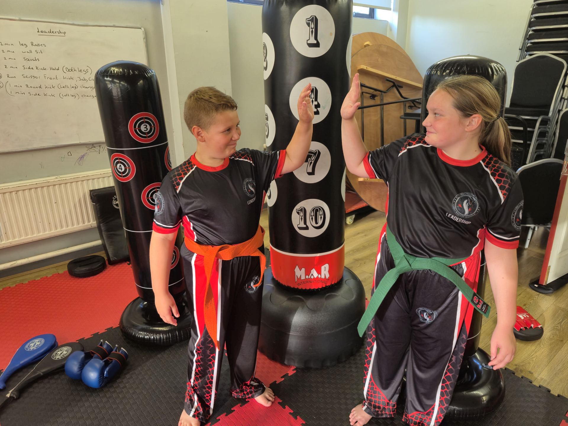 Two Leadership students high-fiving during training